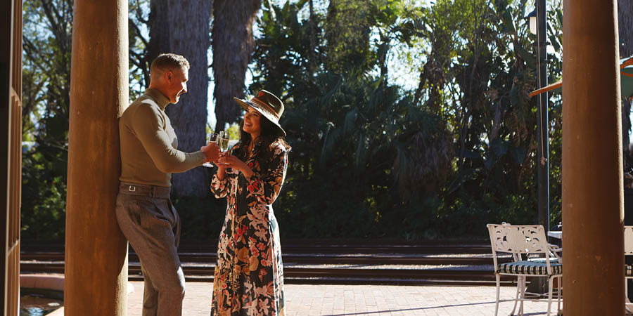 A couple enjoy a drink before boarding their train. 
